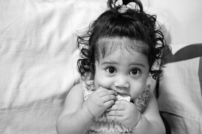 Portrait of cute baby girl eating biscuit