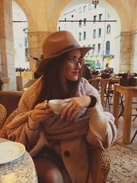 Portrait of young woman sitting at outdoor cafe