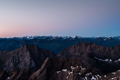 Scenic view of snowcapped mountains against sky at dusk