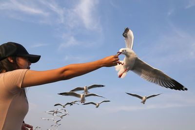 Young woman feeding seagull