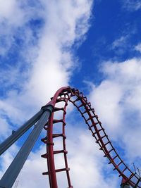 Low angle view of rollercoaster against cloudy sky