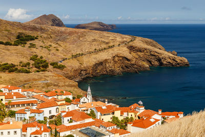 High angle view of townscape by sea against sky