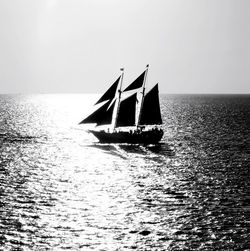 Silhouette of sailboat on sea against sky during sunset