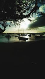 Silhouette of boat sailing in sea during sunset