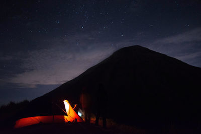 Silhouette bonfire against sky at night