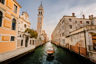 Typical venetian boat as it sails past the church of san giorgio dei greci