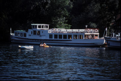 Boat sailing on river against trees