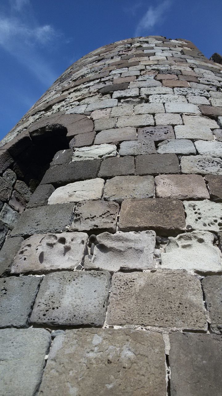 building exterior, architecture, built structure, stone wall, low angle view, brick wall, sky, wall - building feature, sunlight, day, history, outdoors, stone material, pattern, blue, no people, brick, shadow, old, building