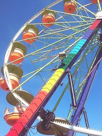 Low angle view of ferris wheel against blue sky