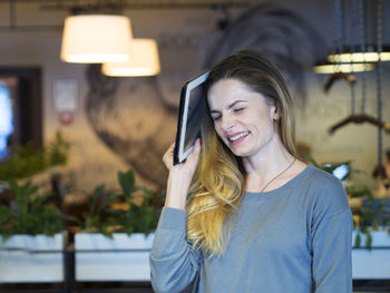 Close-up of smiling young woman using smart phone