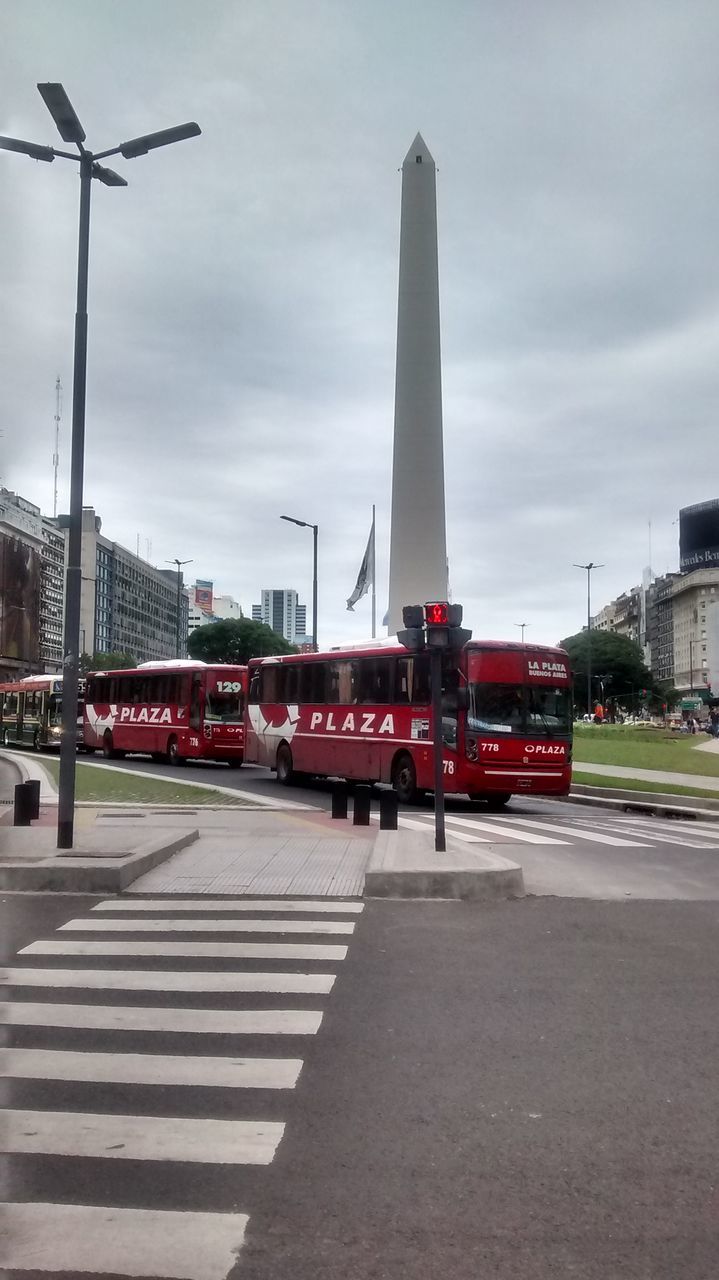 building exterior, architecture, built structure, sky, city, transportation, road, cloud - sky, street, tower, street light, tall - high, cloudy, car, road marking, day, city street, communications tower, travel destinations, outdoors