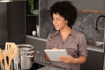 Young woman using mobile phone at home