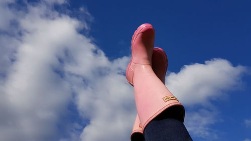 Low angle view of hand against blue sky