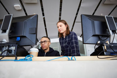 Low angle view of friends looking at computers in university