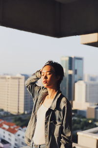 Young woman with eyes closed standing in city