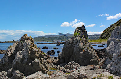 Panoramic view of rocks on beach against sky