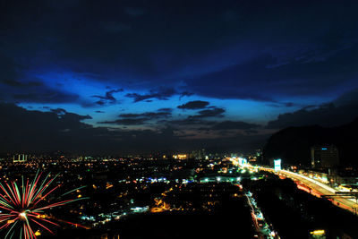 Illuminated cityscape against sky at night