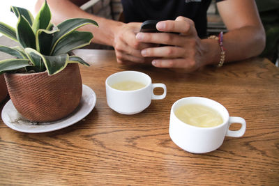 Midsection of coffee cup on table