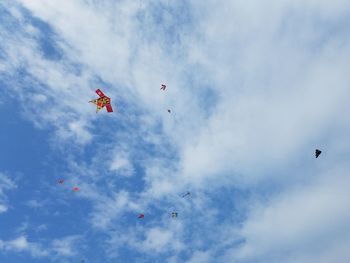 Low angle view of kites flying in sky