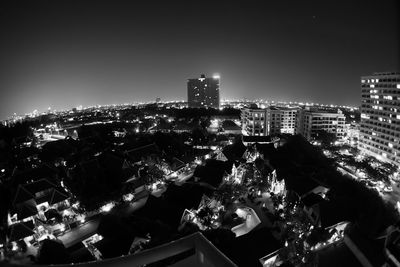 Illuminated cityscape against sky at night