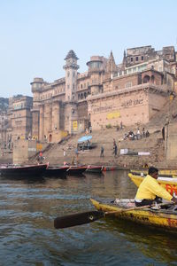 Boats in river with buildings in background