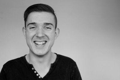 Portrait of young man standing against white background