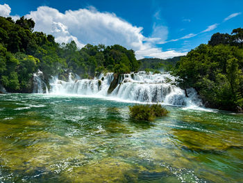 Scenic view of waterfall against sky