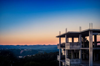 Scenic view of silhouette mountains against clear sky at sunset