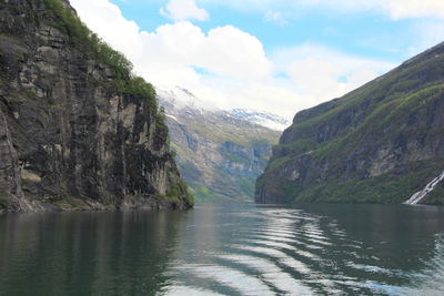 Scenic view of river amidst mountains against sky