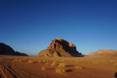 Scenic view of desert against clear blue sky