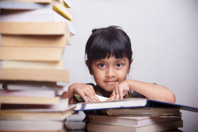 Portrait of happy boy with book on table