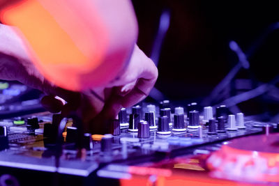 Cropped hand of male dj playing music at nightclub