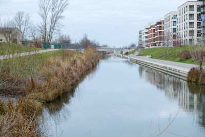 Canal amidst buildings against sky in city