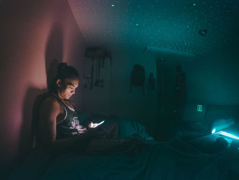 Young man using phone while relaxing on bed at home