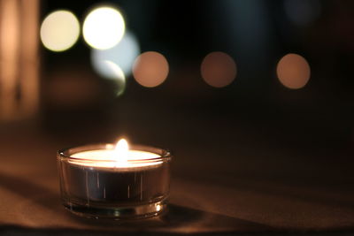 Close-up of illuminated candles on table