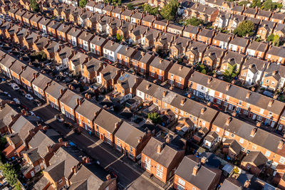 Aerial view above rooftops of back to back terraced houses on a residential estate in north england