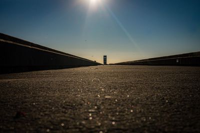 Surface level of road against clear sky on sunny day