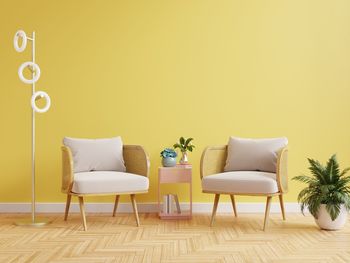Modern living room interior with two armchair and decor on bright yellow wall.3d rendering