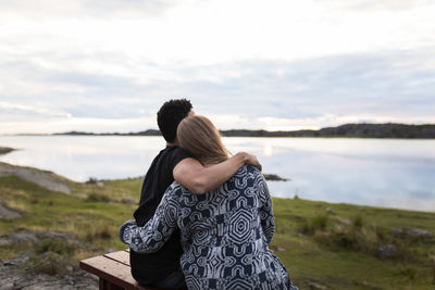 Couple embracing and looking at lake