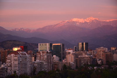 Buildings in city against sky during sunset