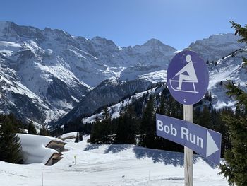 Bob sleigh sign on snowcapped mountains against sky in murren