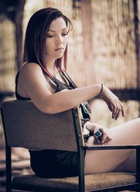 Thoughtful woman sitting on chair at home