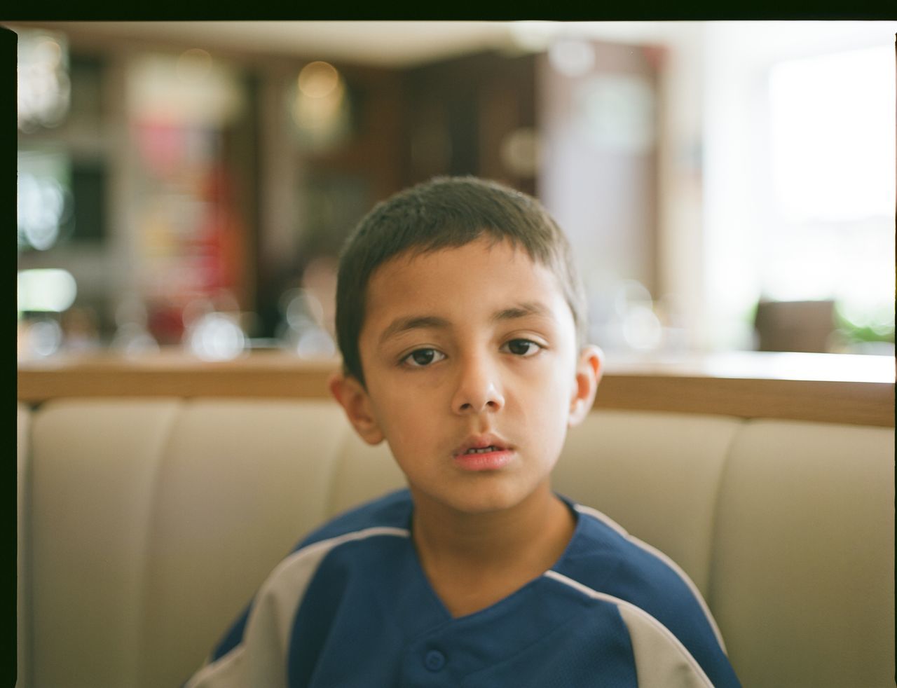 indoors, person, portrait, looking at camera, headshot, lifestyles, front view, transfer print, childhood, head and shoulders, boys, close-up, elementary age, casual clothing, leisure activity, cute, focus on foreground, innocence