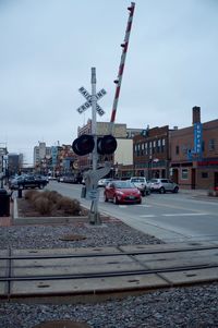 Cars on street in city against sky