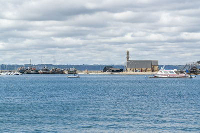 Scenic view of sea by buildings against sky