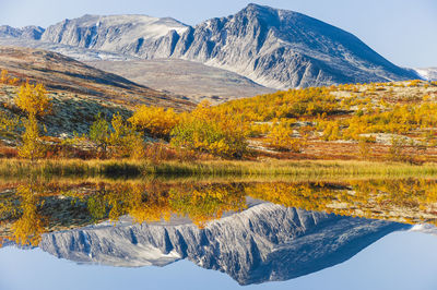 Reflection of mountains and trees in autumn landscape, norway.