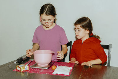 Two beautiful caucasian girls are baking cookies.