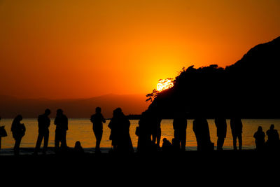 Silhouette people at beach during sunset