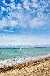 Boats in sea against cloudy sky