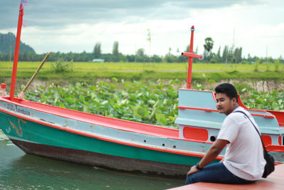 Side view of man sitting on boat